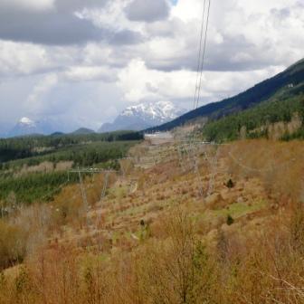 View of the road under the powerlines with mountains in the distance.